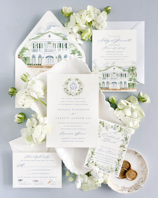 Luxury watercolor wedding invitations for Lowndes Grove in Charleston, South Carolina featuring custom venue artwork, envelope liner, fine art florals, monogram crest, and elegant blue and green wedding stationery styling. Romantic Charleston wedding invitation suite with hand-painted Lowndes Grove illustration, save the date, RSVP card, wax seals, and soft blue heirloom details.